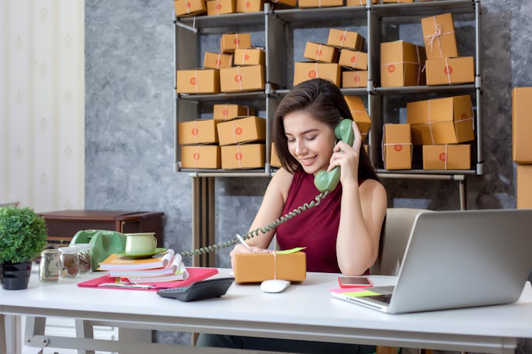 Selling products online. Portrait of a pretty woman phone talking to clients for shipping. Pack and ...