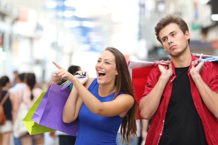 Bored man shopping with his girlfriend in a commercial street