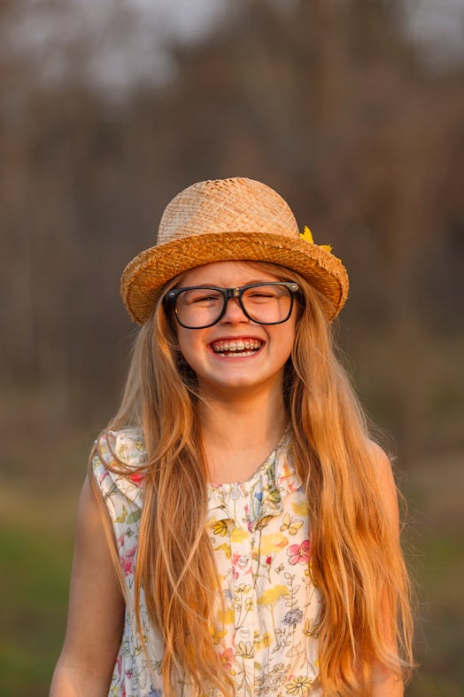 Portrait happy summer mood of joyful young girl in glasses, braces and straw hat, having fun.express...