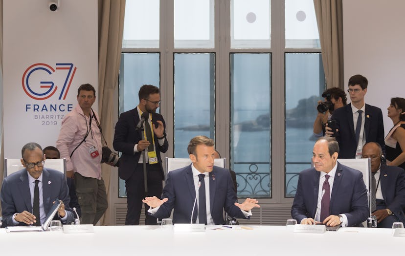 French President Emmanuel Macron, flanked by Rwanda's President Paul Kagame (L) and Egyptian Preside...