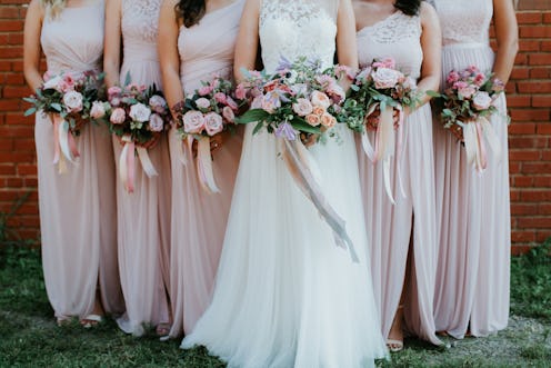 bride and bridesmaids holding wedding bouquets, pink bridesmaids dresses, detail shot, copy space