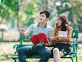 Girl friend and boy friend leaning knowledge by book while there are sitting in the park  