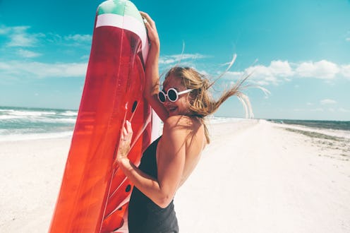 Model with watermelon lilo at the beach. Summer vacations, idyllic scene.