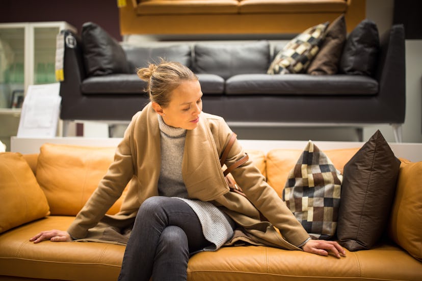 Pretty, young woman choosing the right furniture for her apartme