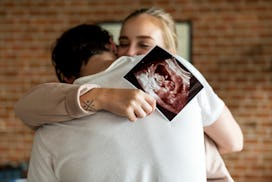 White couple with baby ultrasound photo