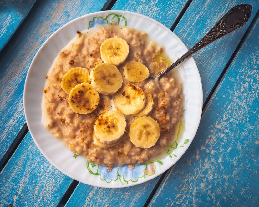 Banana oatmeal with cinnamon on a blue tray, shot from the top angle