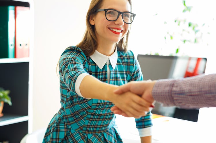 Modern young  business woman with arm extended to handshake