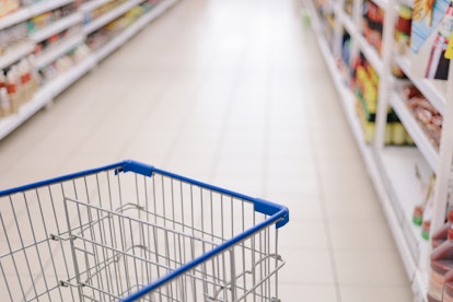 Concept image of buying. Shopping trolley in a Tesco Hypermarket with blurry background of groceries...