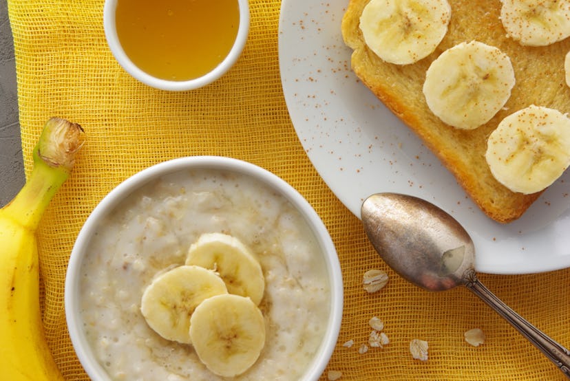 oatmeal with honey and banana with toast on a plate with a spoon of coffee for breakfast top view