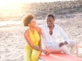 Nice young ethnic black african couple sit down outdoor and enjoy the friendship together smiling an...
