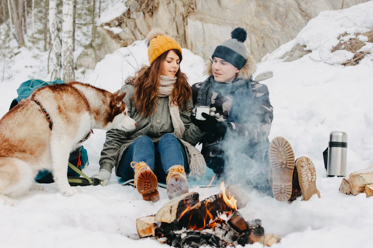 The happy couple with dog haski at the forest nature park in the cold season. Travel adventure love ...