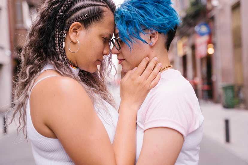 Young lesbian couple kissing and showing affection in the street.