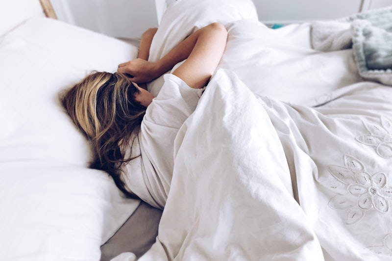 Girl sleeping in an bed with white bed sheets