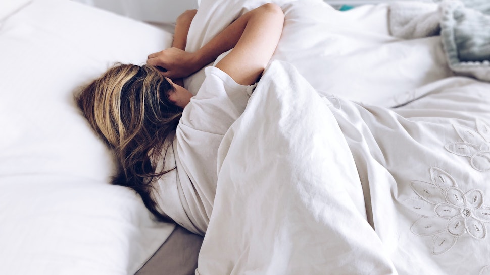 Girl sleeping in an bed with white bed sheets
