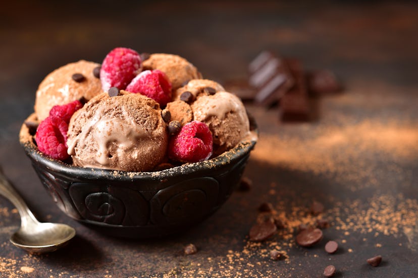 Homemade chocolate ice cream with raspberry and chocolate chips in a bowl on a dark slate,stone or m...