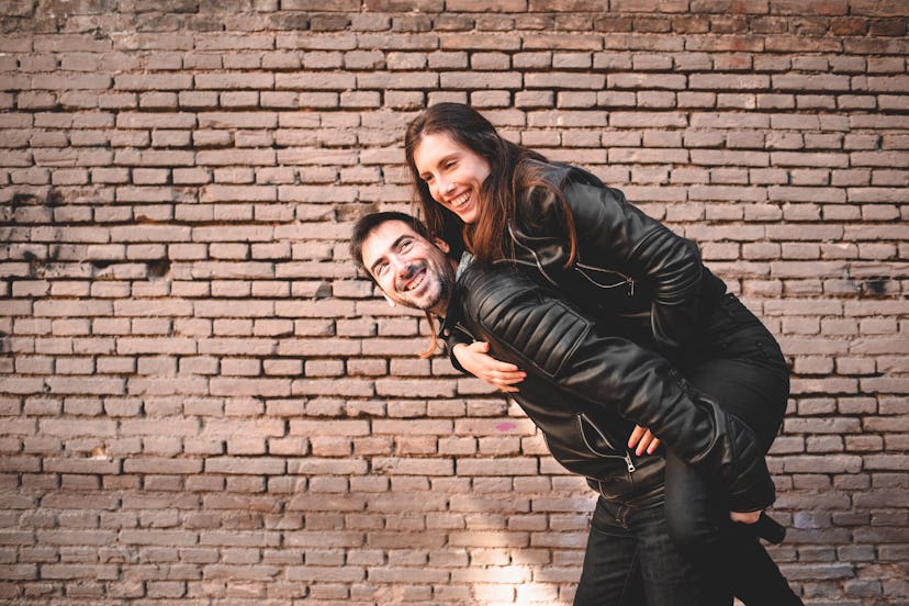 Couple in piggyback having a good time of laughter and love to celebrate their upcoming wedding.