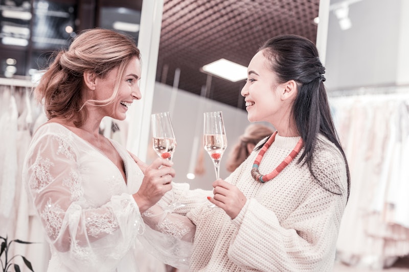 Pleasant communication. Joyful nice women talking about future wedding while drinking champagne