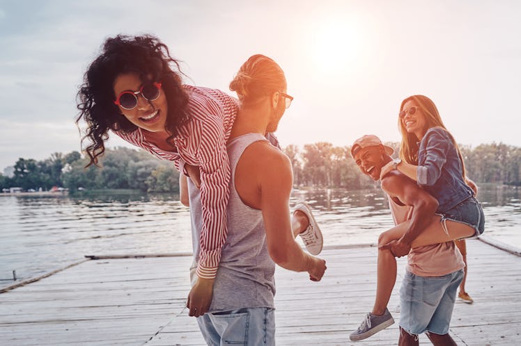 Joy of being in love. Beautiful young couples spending carefree time while standing on the pier