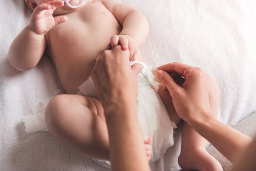 A mom changing her baby's diaper.