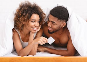 Safety sex concept. Male and female hands holding condom, closeup