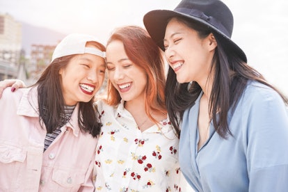 Asian women friends having fun outdoor in a sunny day - Happy trendy girls laughing together - Mille...