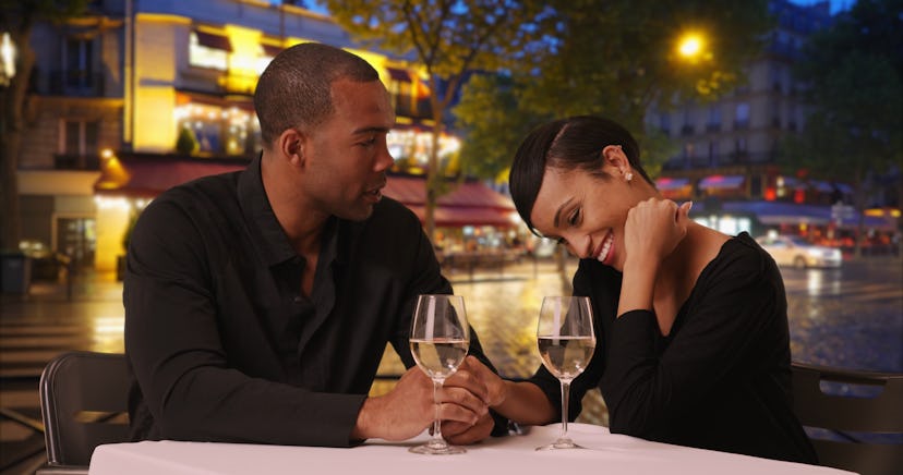 African woman and boyfriend eating at fine-dine restaurant on romantic night out