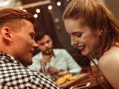Flirting couple. Close-up face portrait of beautiful attractive young-adult cheerful joyful couple f...