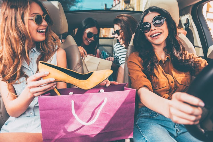 Next stop is lingerie shop! Four beautiful young cheerful women holding shopping bags and looking at...