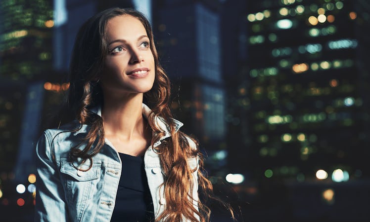 happy woman walking on the night city. Pretty girl looking away. Copy space