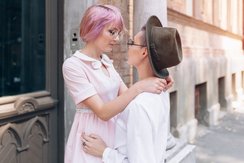 Stylish lesbian couple hugging near the old building in the city