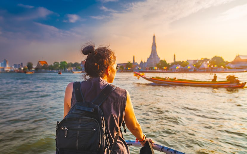 Traveler woman on boat joy view Wat Arun at sunset, Chao Phraya river, Famous water landmark travel ...