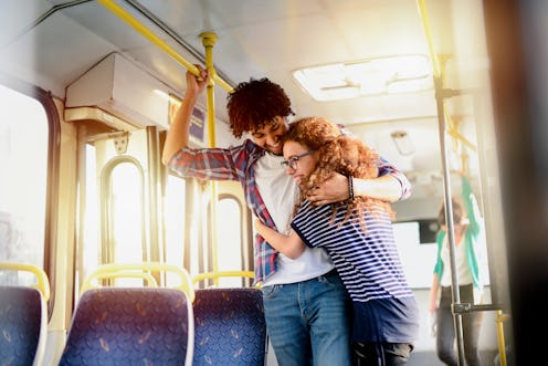 Cute young couple hugging in a public transport. Having fun and traveling together.