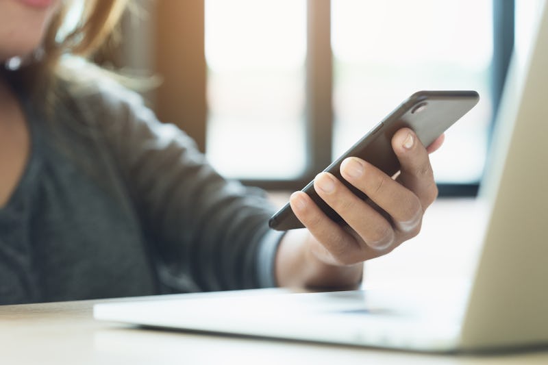 woman use phone on desk in office place