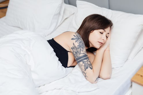 Beautiful young woman sleeping in a white bed.