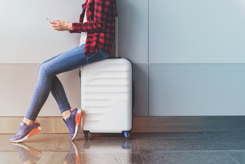 Graceful girl is using mobile phone in modern terminal