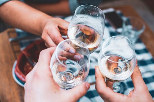 Friends toasting with wine at a bar outdoors