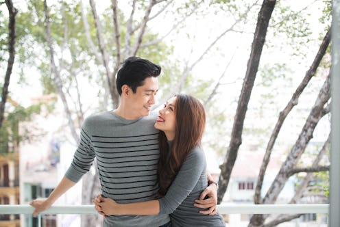 Couple in love sharing genuine emotions and happiness, hugging on the balcony