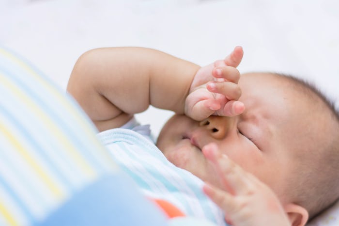Baby rubbing it's eyes, feeling sleepy.