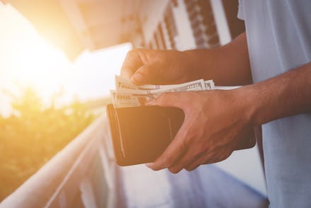 Businessman's hand in suit takes out dollar money from a wallet, money in the wallet.
