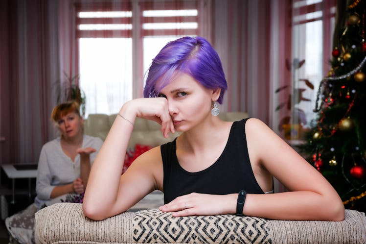 Family problems in the new year - Concept portrait of a mother and daughter with purple hair in a ro...