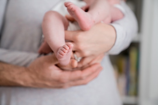 Mom and dad holding baby with close up of feet