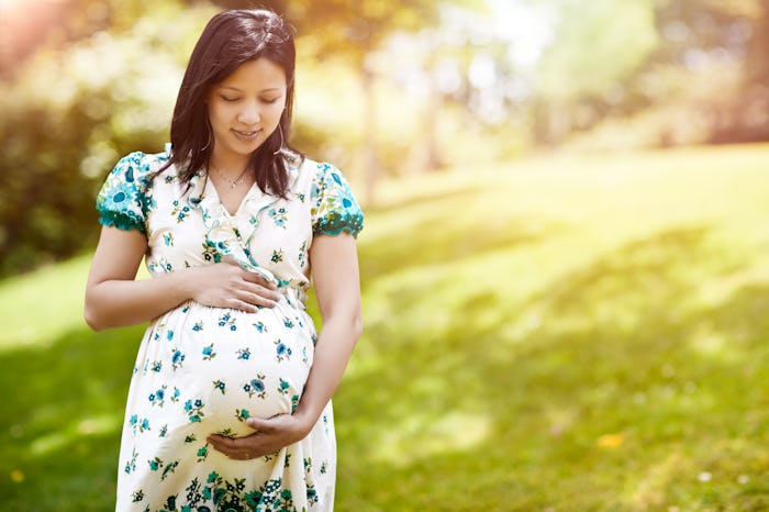 A shot of a beautiful pregnant Asian woman outdoor