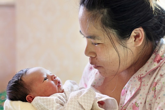 Asian Mother holding her Newborn Baby in narrow focus
