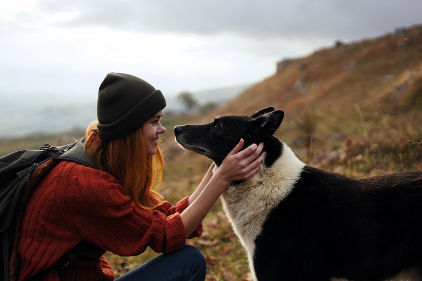  Woman talking to a dog in nature                            