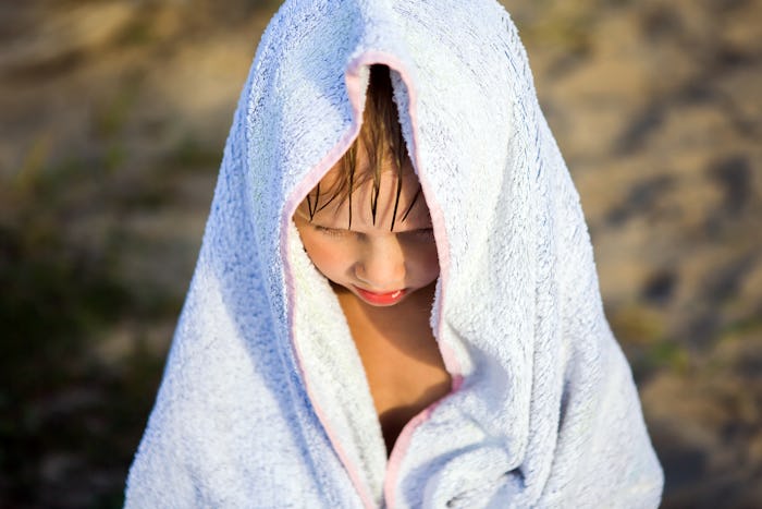 Sad Kid in the Bath Towel on the Summer Beach Portrait closeup