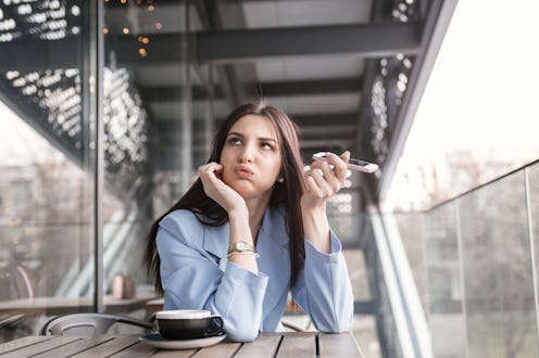Closeup portrait of a beautiful annoyed woman holding phone to side, not listening to conversation g...