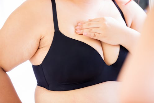 plus size asian woman doing the breast cancer self check