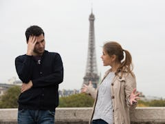 young couple man and woman standing on the bridge on river Seine, Paris, France, in front of Eiffel ...