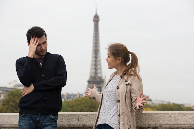 young couple man and woman standing on the bridge on river Seine, Paris, France, in front of Eiffel ...