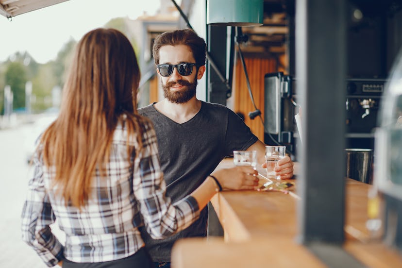 The guy and the girl in the cafe. Couple sitting near bar. Handsome man in a sunglasses